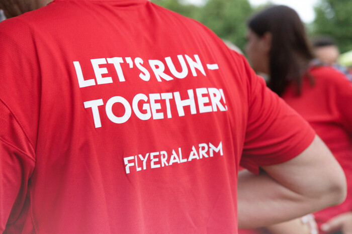 Rückenansicht Person mit rotem T-Shirt „Let’s Run Together“ draußen